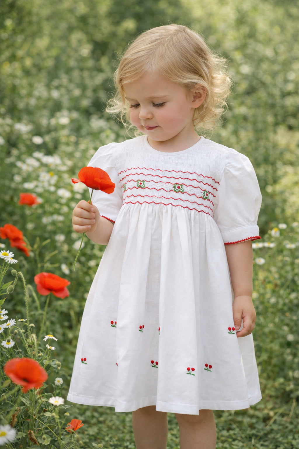 Mädchen trägt Tavolinchen weißes Kleid mit Smokstickerei und gestickten Kirschen für besondere Anlässe