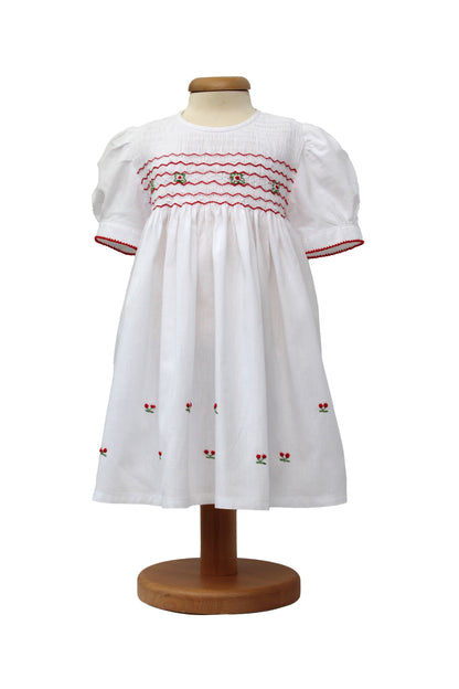 Tavolinchen weißes Mädchenkleid mit Smokstickerei, roten Zickzack-Borten und gestickten Kirschen aus Baumwolle